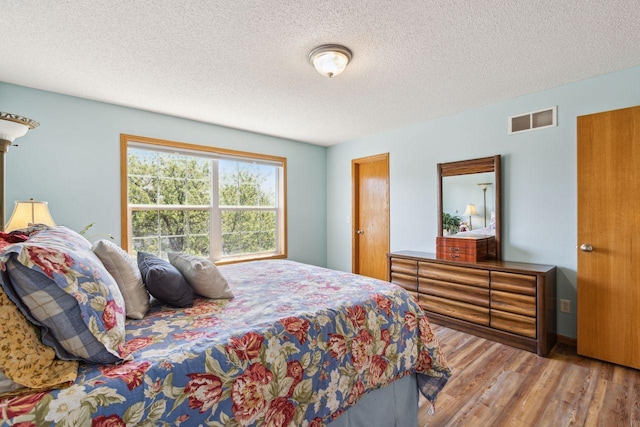 bedroom featuring wood finished floors and a textured ceiling