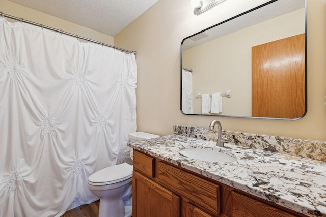 full bathroom featuring a textured ceiling, toilet, vanity, wood finished floors, and a shower with curtain
