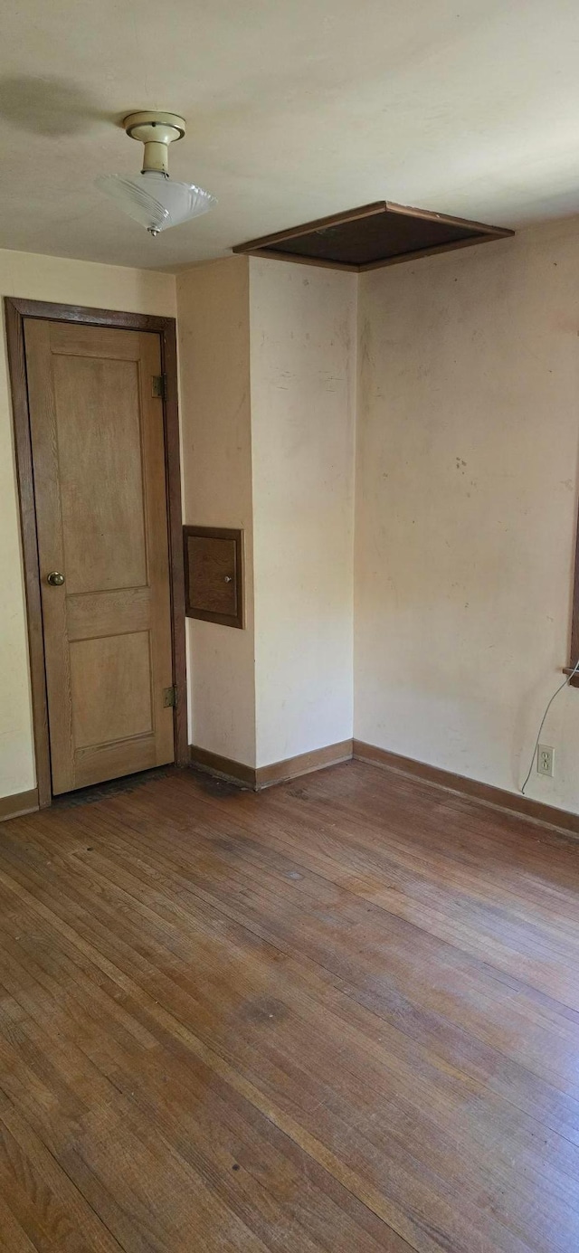 unfurnished room featuring dark wood-style floors and baseboards