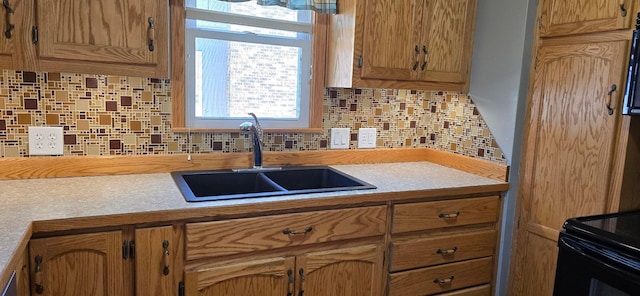 kitchen with a sink, decorative backsplash, and light countertops