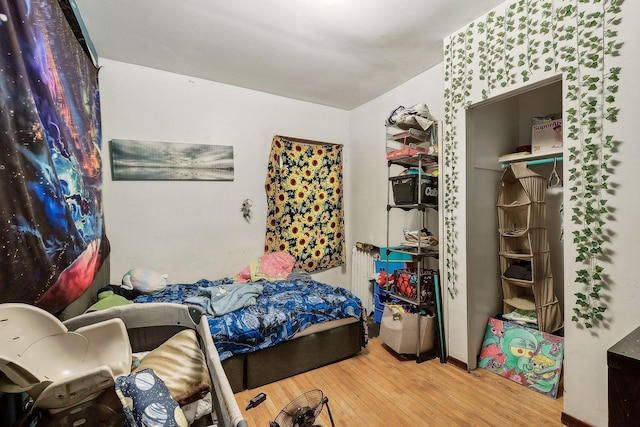 bedroom with radiator and wood finished floors