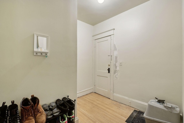 foyer entrance featuring baseboards and light wood-style floors