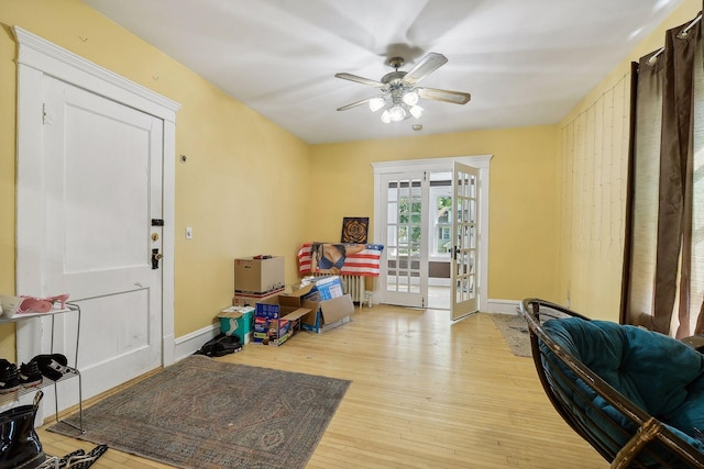 foyer entrance featuring french doors, light wood-type flooring, ceiling fan, and baseboards