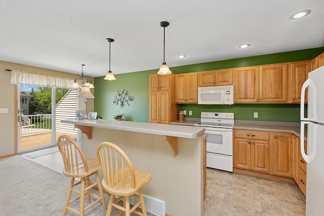 kitchen featuring white appliances, a kitchen breakfast bar, light countertops, decorative light fixtures, and recessed lighting