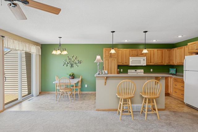 kitchen with white appliances, plenty of natural light, light colored carpet, a chandelier, and a textured ceiling