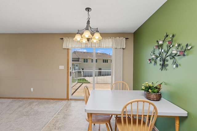 dining space featuring a chandelier, baseboards, and carpet