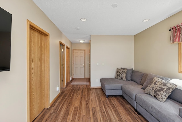 living room featuring wood finished floors, recessed lighting, and baseboards