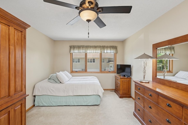 bedroom featuring light colored carpet, baseboards, and a ceiling fan