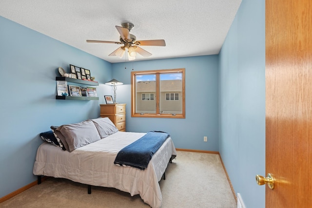 carpeted bedroom featuring baseboards, a textured ceiling, and ceiling fan