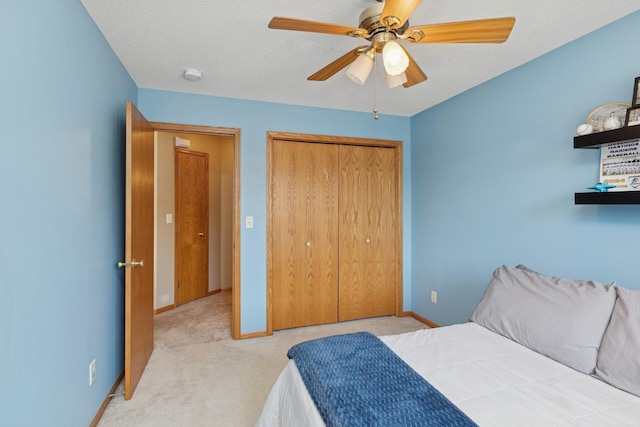 carpeted bedroom featuring baseboards, a closet, and ceiling fan
