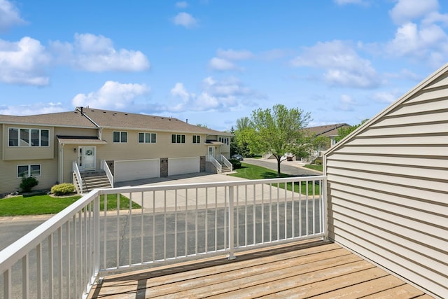 wooden terrace featuring stairs and an attached garage