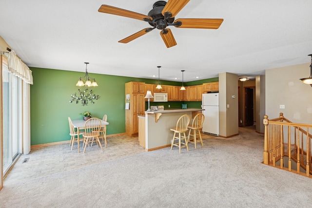 kitchen featuring white appliances, light carpet, a breakfast bar, and a chandelier
