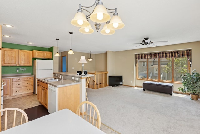 kitchen with a ceiling fan, white dishwasher, a kitchen island with sink, light colored carpet, and a sink