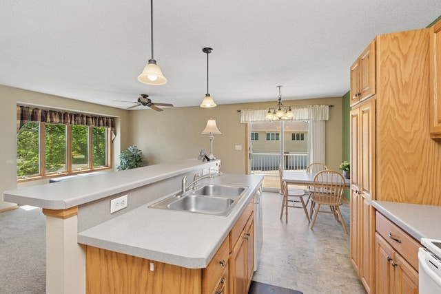 kitchen featuring a sink, light countertops, a kitchen island with sink, hanging light fixtures, and ceiling fan