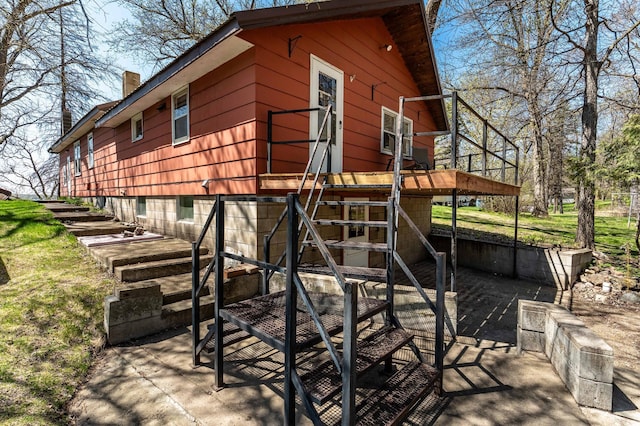 23711 Clarissa Haven Dr, Girard Twp, MN 56551 - view of home's exterior featuring a chimney, stairs, and a wooden deck