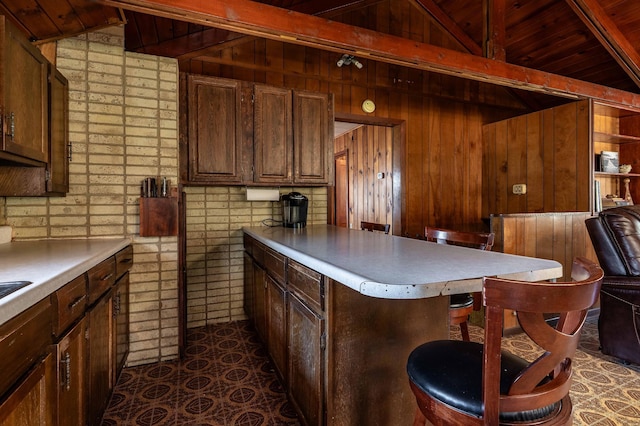 23711 Clarissa Haven Dr, Girard Twp, MN 56551 - kitchen with wood walls, a breakfast bar area, light countertops, wood ceiling, and a peninsula