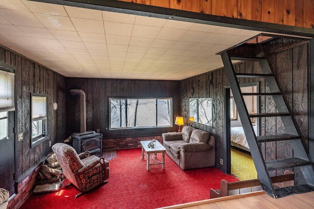 23711 Clarissa Haven Dr, Girard Twp, MN 56551 - living area featuring a wood stove, healthy amount of natural light, stairway, and wooden walls