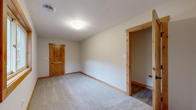 empty room with baseboards and light colored carpet