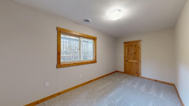 unfurnished room with light carpet and baseboards
