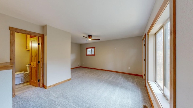 empty room with light carpet, healthy amount of natural light, and baseboards