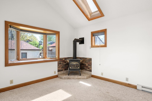 unfurnished living room with a wood stove, carpet floors, lofted ceiling, a skylight, and baseboards