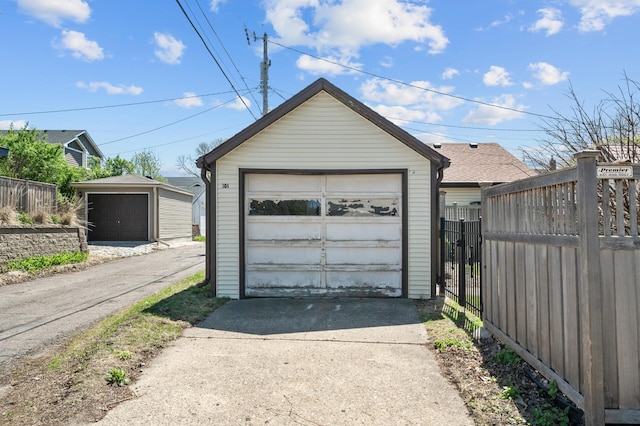 detached garage with driveway and fence