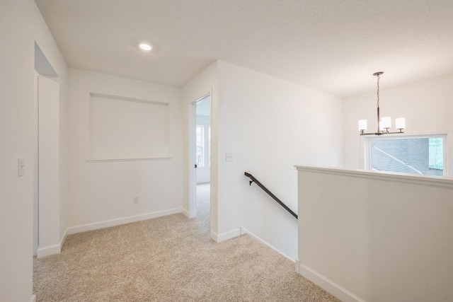 corridor with baseboards, an upstairs landing, recessed lighting, carpet flooring, and a notable chandelier