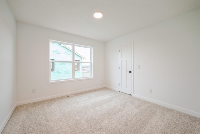 unfurnished room with light carpet, baseboards, and visible vents