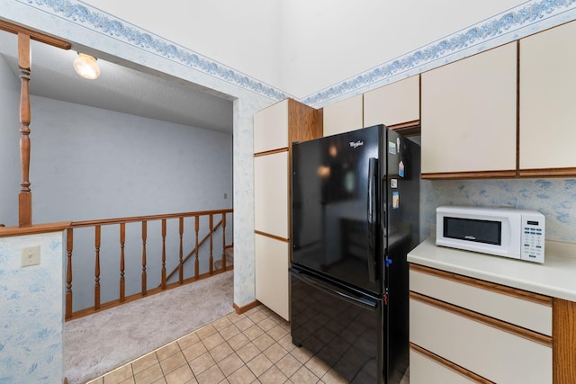 38546 Grand Ave, North Branch, MN 55056 - kitchen with freestanding refrigerator, white microwave, light countertops, light carpet, and wallpapered walls