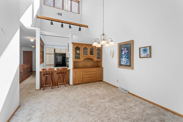 38546 Grand Ave, North Branch, MN 55056 - dining space with a towering ceiling, light carpet, baseboards, and a chandelier