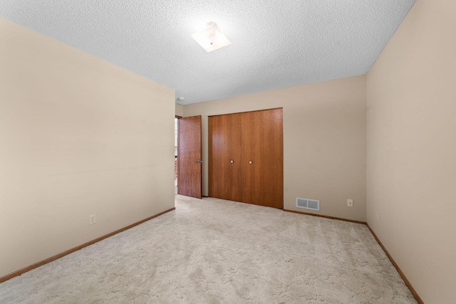 38546 Grand Ave, North Branch, MN 55056 - unfurnished bedroom with a closet, carpet, a textured ceiling, and baseboards