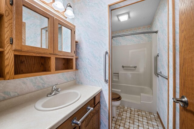 38546 Grand Ave, North Branch, MN 55056 - bathroom featuring wallpapered walls, toilet, vanity, and tile patterned floors
