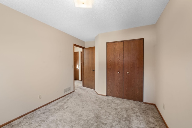 38546 Grand Ave, North Branch, MN 55056 - unfurnished bedroom with carpet floors, a closet, baseboards, and a textured ceiling