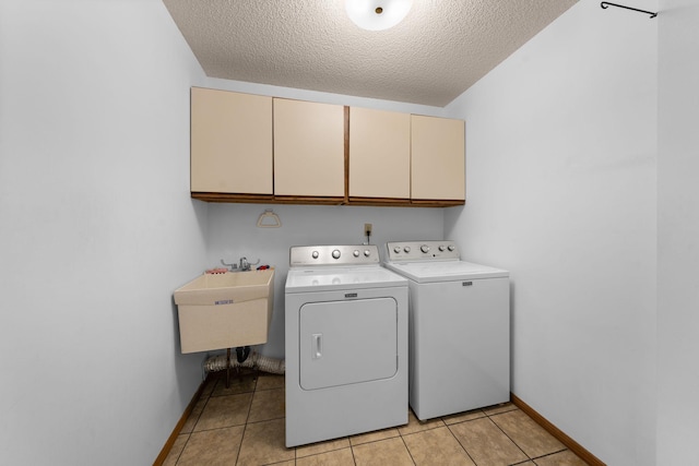 38546 Grand Ave, North Branch, MN 55056 - clothes washing area featuring cabinet space, washing machine and dryer, a textured ceiling, baseboards, and light tile patterned floors