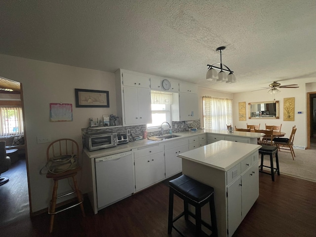 112 Walnut St, Dawson, MN 56232 - kitchen featuring dishwasher, light countertops, dark wood finished floors, a sink, and plenty of natural light