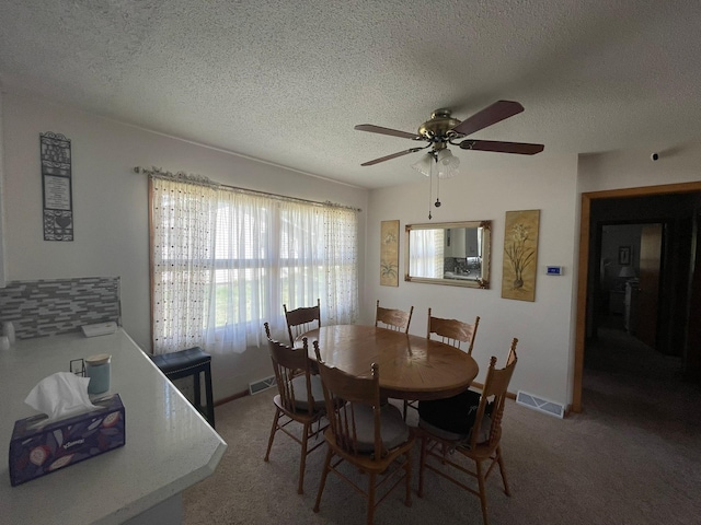 112 Walnut St, Dawson, MN 56232 - dining room featuring a ceiling fan, a textured ceiling, light carpet, and baseboards