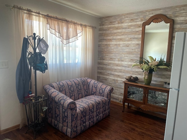 112 Walnut St, Dawson, MN 56232 - sitting room featuring wooden walls, wood finished floors, and a textured ceiling