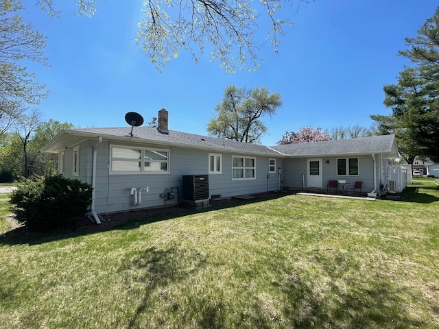 112 Walnut St, Dawson, MN 56232 - rear view of house featuring a yard, cooling unit, a chimney, and a patio