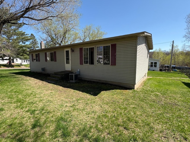 307 Deerwood Ln S, Onamia, MN 56359 - view of front facade featuring a front lawn, central AC unit, and a chimney