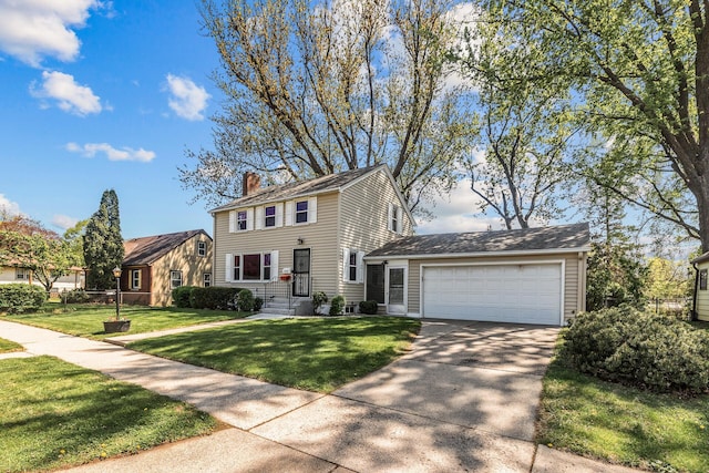 colonial inspired home with a chimney, driveway, an attached garage, and a front lawn
