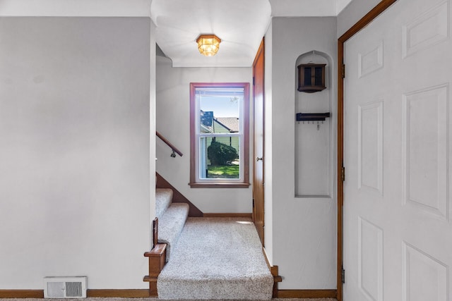 foyer entrance with baseboards and stairway