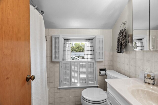 full bath with tile walls, toilet, and vanity