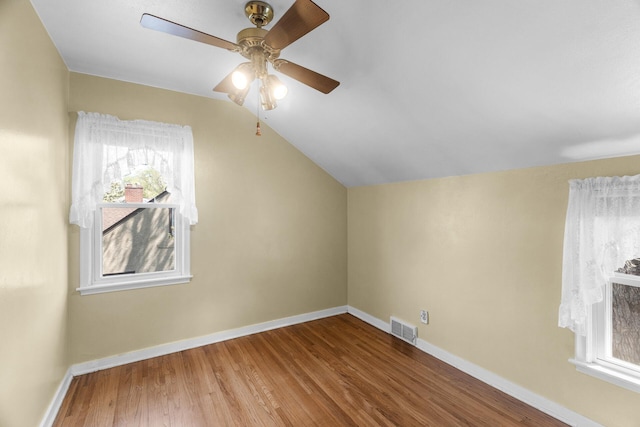 bonus room featuring wood finished floors, lofted ceiling, a ceiling fan, healthy amount of natural light, and baseboards