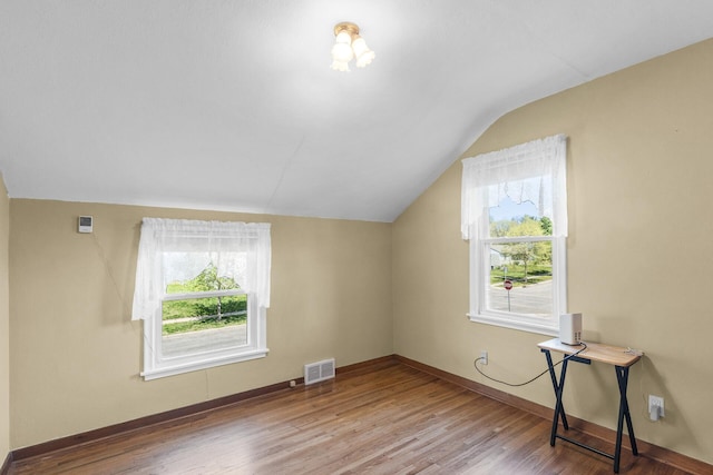 bonus room with vaulted ceiling, wood finished floors, and baseboards