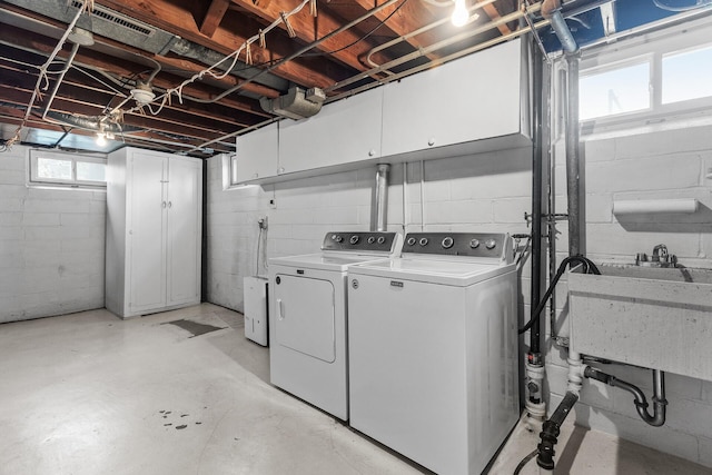 washroom with cabinet space and separate washer and dryer