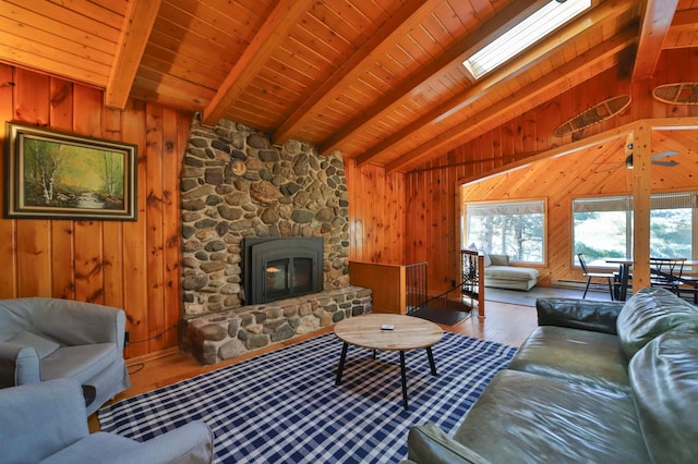 living area with hardwood / wood-style floors, wooden walls, a stone fireplace, and wooden ceiling