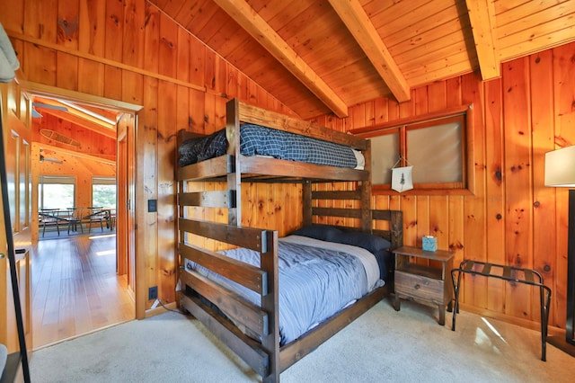 carpeted bedroom with wooden walls and wood ceiling