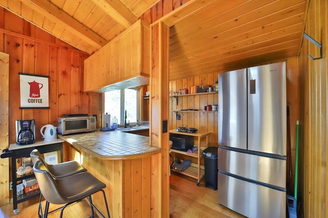 2202 Pine View Blvd, Motley, MN 56466 - kitchen featuring stainless steel appliances, tile countertops, light wood-style floors, wooden ceiling, and wooden walls