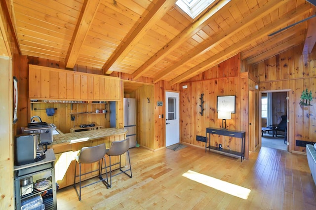 2202 Pine View Blvd, Motley, MN 56466 - kitchen with tile countertops, wood walls, light wood finished floors, wooden ceiling, and freestanding refrigerator
