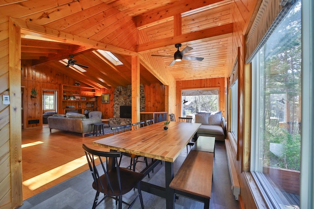 2202 Pine View Blvd, Motley, MN 56466 - dining space with ceiling fan, wooden walls, plenty of natural light, lofted ceiling, and a fireplace